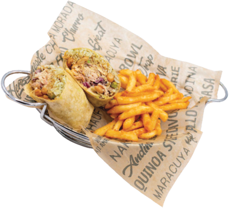 A metal basket lined with printed paper holds a halved wrap filled with shredded chicken and vegetables, served alongside a portion of seasoned curly fries.